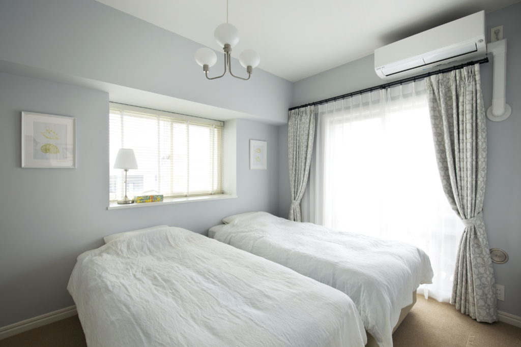 カーペットとブルーの塗装が柔らかな雰囲気を演出する寝室